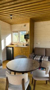 a kitchen with a table and chairs in a room at Prozori Boiky in Lopushanka-Khomyna