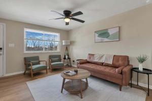 a living room with a couch and a ceiling fan at The Neff Nest - 1 BR Flat in Columbus