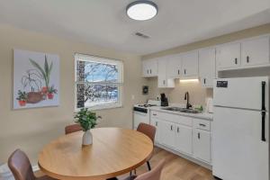 a kitchen with a table and a white refrigerator at The Neff Nest - 1 BR Flat in Columbus