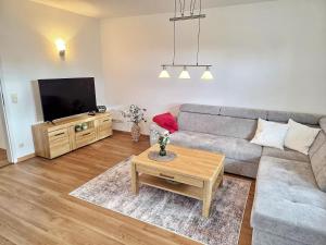 a living room with a couch and a tv at Am Pappelweg - ABC620 in Hohen Viecheln