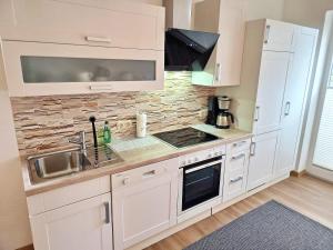a kitchen with white cabinets and a sink at Am Pappelweg - ABC620 in Hohen Viecheln