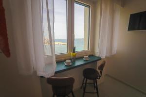 ein Zimmer mit Fenster, mit einem Tisch und zwei Stühlen in der Unterkunft Mareviglia in Gallipoli