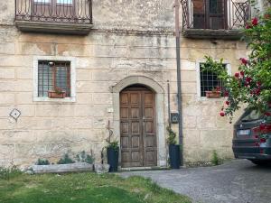 a building with a wooden door and two windows at La Casetta non è soltanto un alloggio, è storia! in Trentinara
