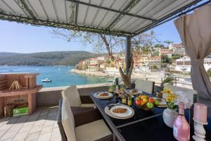 a table with food and a view of the water at Riva Luxury Seafront in Rabac