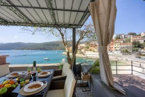 a table with food and a view of the water at Riva Luxury Seafront in Rabac