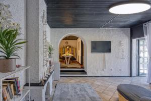 a room with a hallway with a table and a tv at Riva Luxury Seafront in Rabac