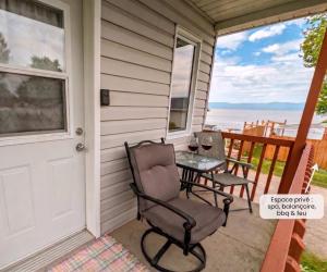 a patio with a table and chairs on the front of a house at Chalet #10 - Spa & Fireplace in Cap-Saint-Ignace
