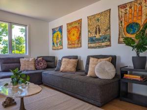 a living room with a couch and paintings on the wall at Chalet #10 - Spa & Fireplace in Cap-Saint-Ignace