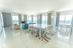 a white living room with a table and chairs at Villa Doris Suites in Lagos