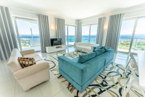 a living room with a blue couch and chairs at Villa Doris Suites in Lagos
