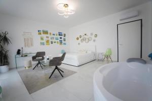 ein weißes Zimmer mit Badewanne, Bett und Stühlen in der Unterkunft Mareviglia in Gallipoli + 119 Fotos