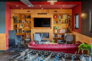 a living room with a red couch and a tv at Eklo Hotels Lille in Lille