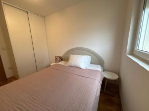 a small bedroom with a bed and a window at Boke vidik in Savina