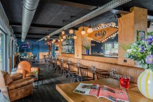 a restaurant with tables and chairs and a bar at Eklo Hotels Lille in Lille