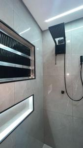 a bathroom with a shower with a laptop on the wall at Hostel Pouso Gru - Translado Aeroporto Gru grátis in Guarulhos