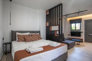 a bedroom with a large bed with towels on it at Central Point - Kallithies Village Square by GM in Kalithies