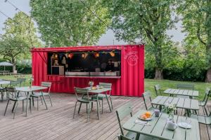 a red tent on a deck with tables and chairs at Eklo Hotels Lille in Lille