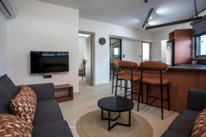 a living room with a couch and a bar at Central Point - Kallithies Village Square by GM in Kalithies