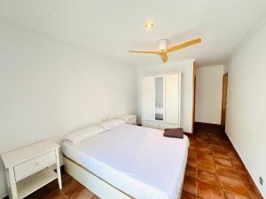 a bedroom with a bed and a ceiling fan at Apartamentos Blanes Petit in Blanes