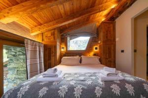 a bedroom with a large bed with towels on it at Chalet Les Airelles in Valtournenche