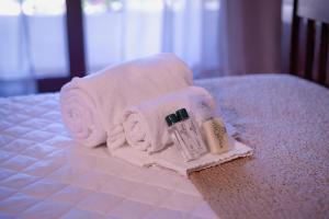a pile of towels and a bottle of lotion on a bed at Hotel Renar in Fraiburgo