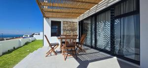 a balcony with two chairs and awning on a house at Sky & Sea in St. Helena Bay
