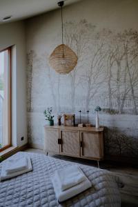 a bedroom with a bed and a wall with trees at Gardiasówka na Roztoczu in Chlewiska