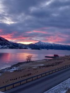 a sunset over a body of water with a road at Fjord & Fjell Idyll in Tunheim