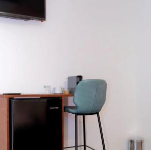 a chair sitting in front of a desk with a television at Narjis in Dzaoudzi