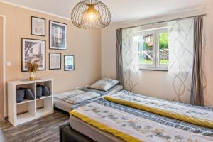two beds in a room with a window at Fewo Franken in Goldkronach