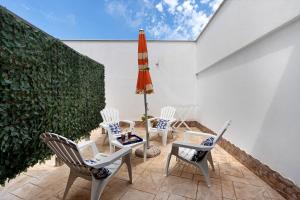 a patio with chairs and an umbrella and a table at Bnb La Rocca San Vito Lo Capo in San Vito lo Capo