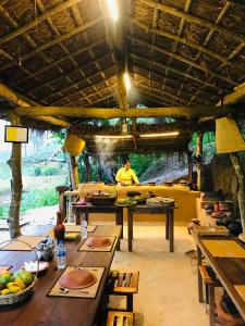 a man standing in the middle of a room with tables at Mr Arachchi Luxury Cabana in Ella