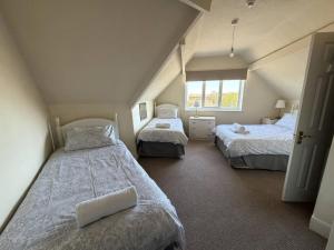 a attic bedroom with two beds and a window at Ryburn Lodge in Bridlington