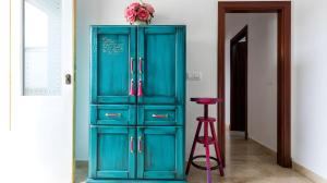a blue cabinet with a pink stool in a room at Apartamento Aguamarina con terraza in Chiclana de la Frontera