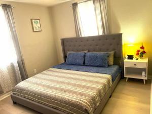a bedroom with a bed with blue pillows on it at A Poolside Paradise in Pensacola