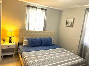 a bedroom with a bed with blue pillows and a window at A Poolside Paradise in Pensacola