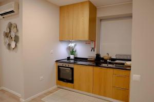 a kitchen with wooden cabinets and a sink at Casa Ponte de São Gonçalo in Amarante