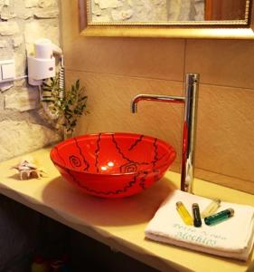 a red bowl sitting on top of a bathroom counter at Petra Nova Villas in Mochlos