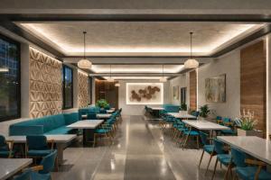 a dining room with tables and blue chairs at Hotel Royal Ashoka in Rājgīr