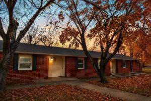 a red brick house with trees in front of it at Skylark Motel by OYO in Bedford