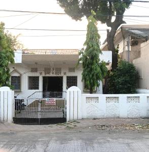 a white house with a fence in front of it at Shukla home stay in Jabalpur
