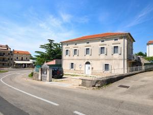 an old white building on the side of a road at Villa 1902 Omišalj in Omišalj