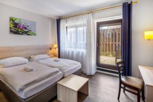 a hotel room with two beds and a window at Hotel Deitmer in Rhede