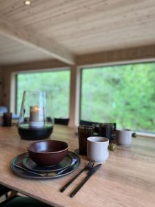 a wooden table with plates and utensils on it at By the River in Vinje +48 photos