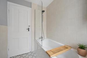 a white bathroom with a shower and a tub at Rockland Retreat - Near Crosby Beach & Liverpool in Waterloo +43 photos