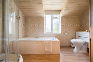a bathroom with a tub and a toilet and a window at The White House, Tunstall in Tunstall +23 photos