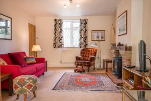 a living room with a red couch and chairs at The White House, Tunstall in Tunstall