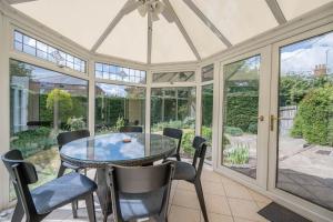 a conservatory with a glass table and chairs at The White House, Tunstall in Tunstall