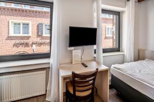 a bedroom with a desk with a computer and a bed at Hotel Deitmer in Rhede