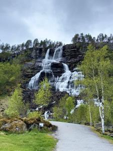 a waterfall on the side of a mountain at By the River in Vinje